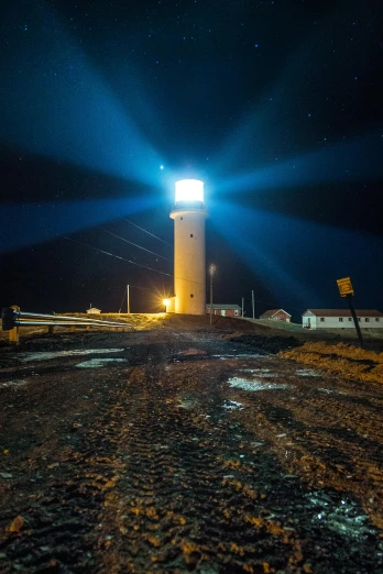 a light house sitting on top of a dirt road, by Hallsteinn Sigurðsson, streetlight at night, nightlife, at nighttime