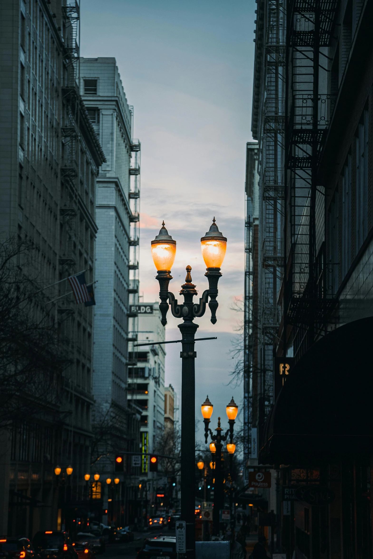 a city street filled with lots of tall buildings, by Greg Rutkowski, unsplash contest winner, renaissance, one single gas lamp, washington state, gothic lighting, soft lights