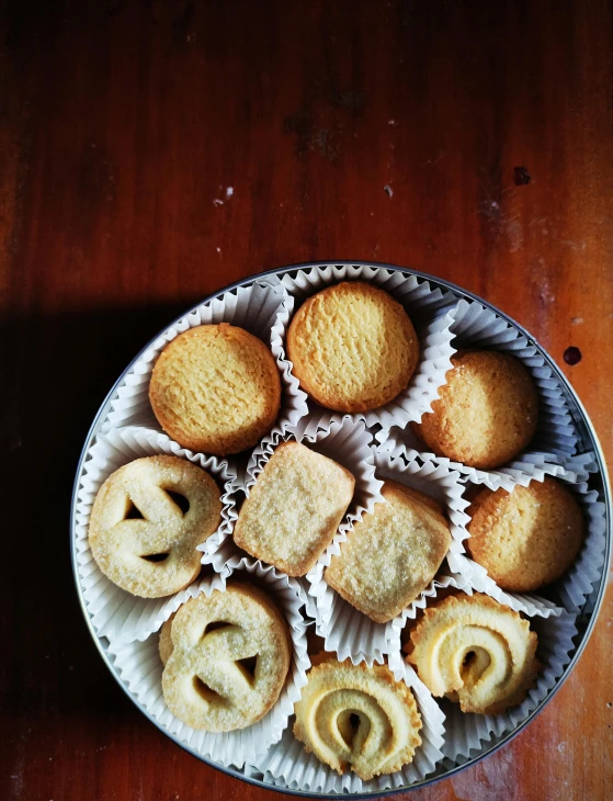 a plate of cookies sitting on top of a wooden table, by Bernardino Mei, pexels contest winner, dau-al-set, tins of food on the floor, diecut, vanilla, thumbnail