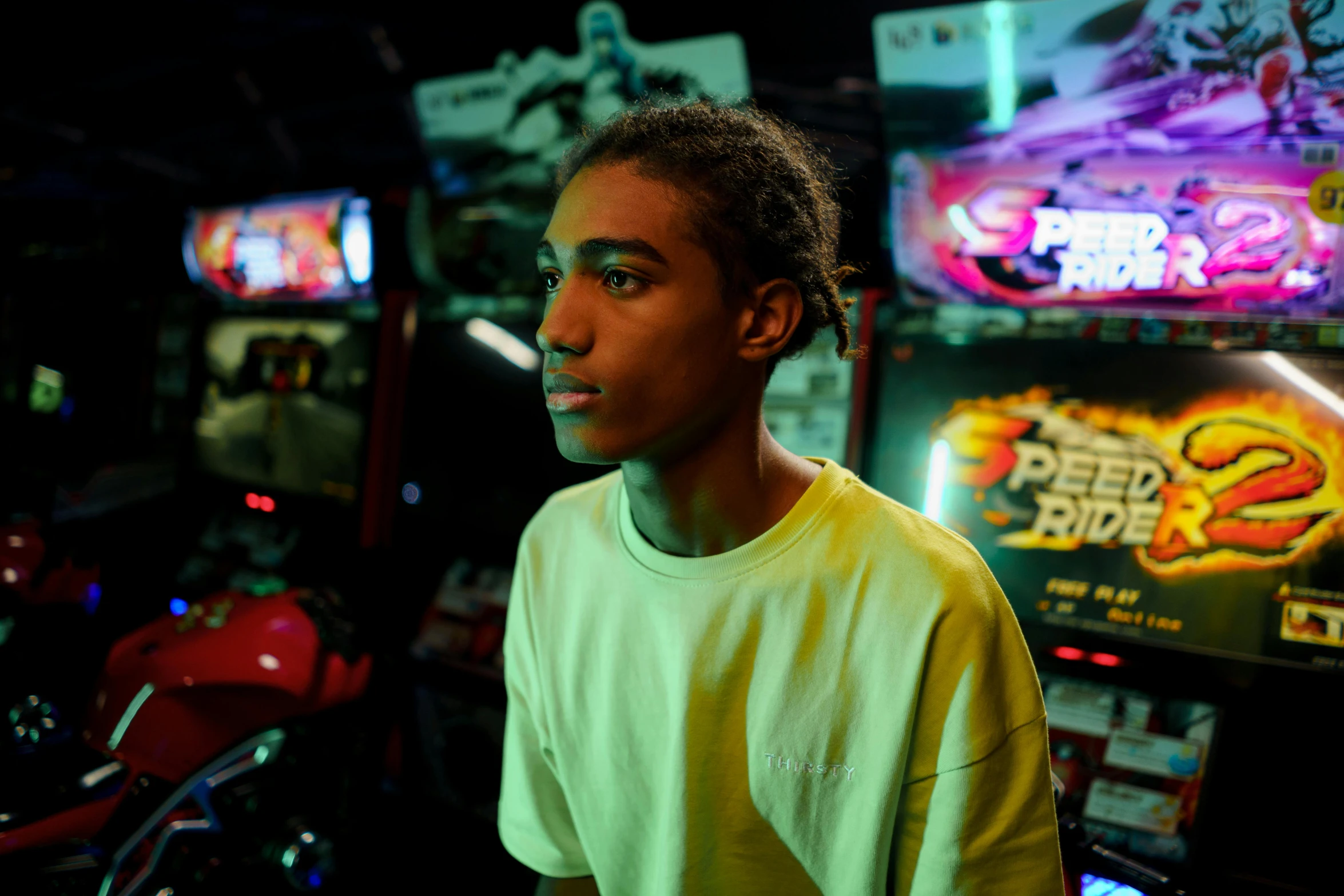 a young man standing in front of a row of video games, a portrait, instagram, process art, ap news photograph, a busy arcade, brown skinned, serious