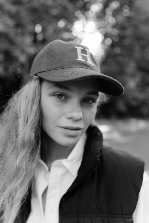 a black and white photo of a woman wearing a hat, by Sara Saftleven, teenage female schoolgirl, hermes, white baseball cap, ellie victoria gale