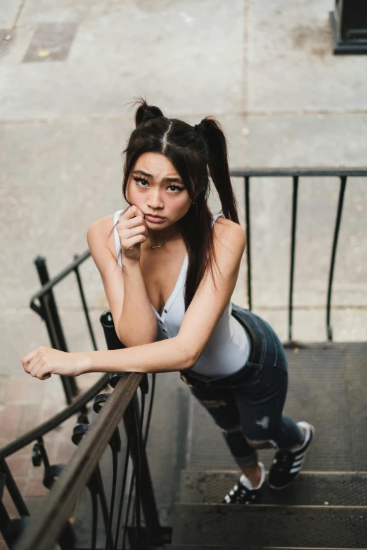 a woman standing at the top of a flight of stairs, inspired by Feng Zhu, trending on pexels, realism, pigtails hair, madison beer girl portrait, pouting, in new york city