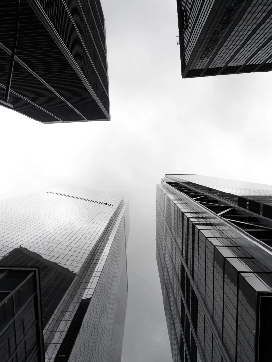 a black and white photo of tall buildings, by Adam Rex, pexels contest winner, gopro photo, gray sky, corporate, the image is futuristic