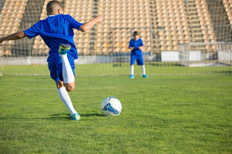 a young boy kicking a soccer ball on a field, a picture, shutterstock, figuration libre, square, sportspalast amphitheatre, long shot from back, 15081959 21121991 01012000 4k