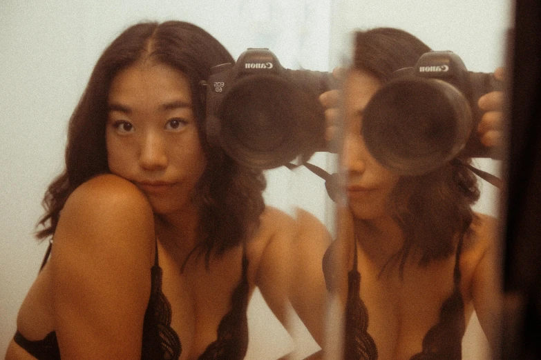 a woman taking a picture of herself in a mirror, inspired by Ren Hang, unsplash, photorealism, wearing bra, shot with a arriflex 35 ii, portrait of christy ren, taken in the early 2020s