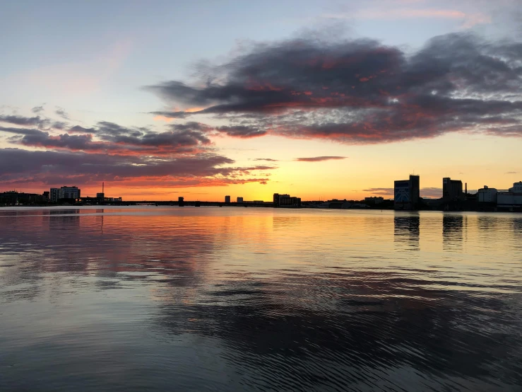 a large body of water with buildings in the background, by Washington Allston, pexels contest winner, hurufiyya, large twin sunset, # nofilter, multiple stories, espoo