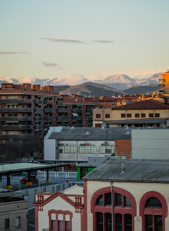 a view of a city with mountains in the background, by Modest Urgell, graffiti, snow capped mountains, high quality image”, taken at golden hour, gigapixel photo