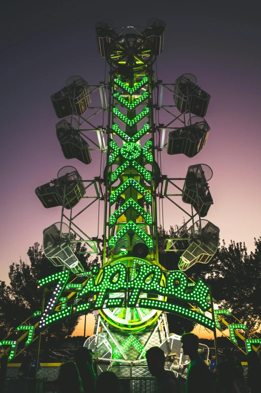 a carnival ride is lit up with green lights, by Jason Felix, zippers, tower, taken at golden hour, null