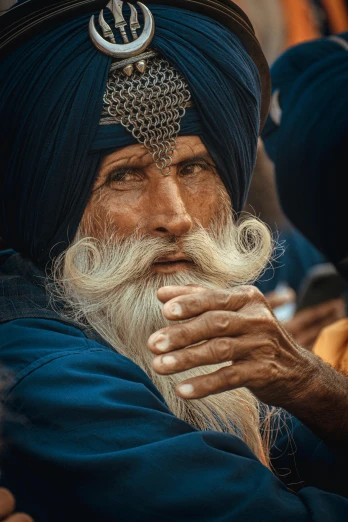 a man with a long beard wearing a turban, by Manjit Bawa, pexels contest winner, cinematic blue and gold, relaxed dwarf with white hair, square masculine facial features, a pilgrim