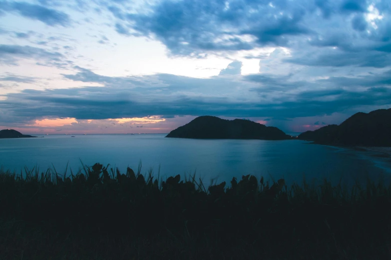 a view of a body of water under a cloudy sky, a picture, unsplash contest winner, sumatraism, twilight ; wide shot, many islands, hills and ocean, fan favorite