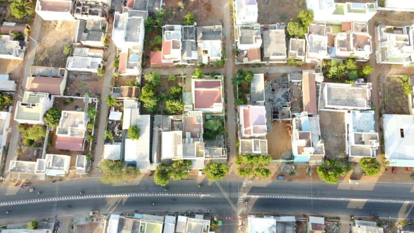 an aerial view of a city with lots of buildings, unsplash, photorealism, kerala village, inter dimensional villa, flattened, standing in township street