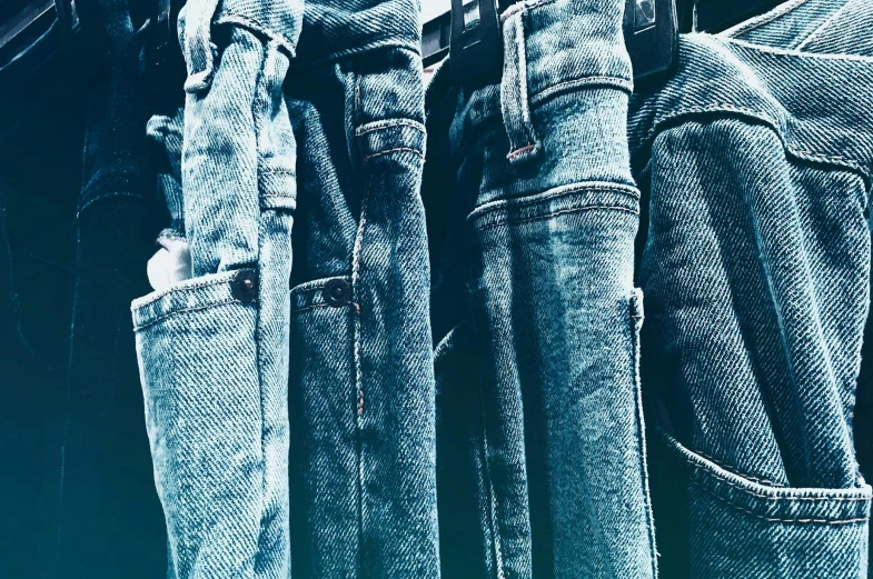 a bunch of jeans hanging on a clothes rack, trending on unsplash, renaissance, grainy quality, wearing blue, instagram photo, clones
