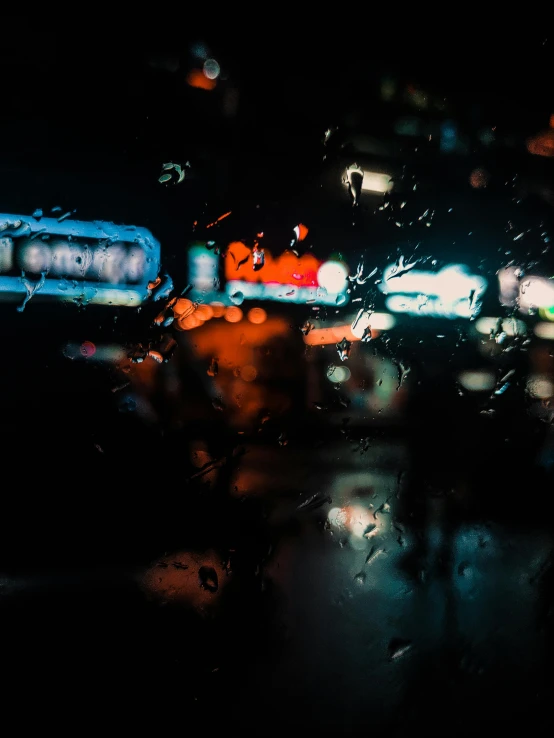 a blurry photo of a city street at night, inspired by Elsa Bleda, unsplash contest winner, visual art, window ( rain ), orange and cyan lighting, “gas station photography, wet reflections in square eyes