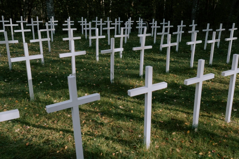 a field of white crosses with trees in the background, by Attila Meszlenyi, unilalianism, helsinki, all skeletons, 1 9 9 0 s, october