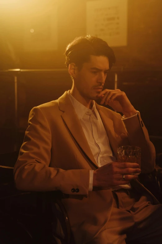 a man sitting in a chair talking on a cell phone, a portrait, unsplash, renaissance, speakeasy bar background, mark edward fischbach, tan suit, still from a music video