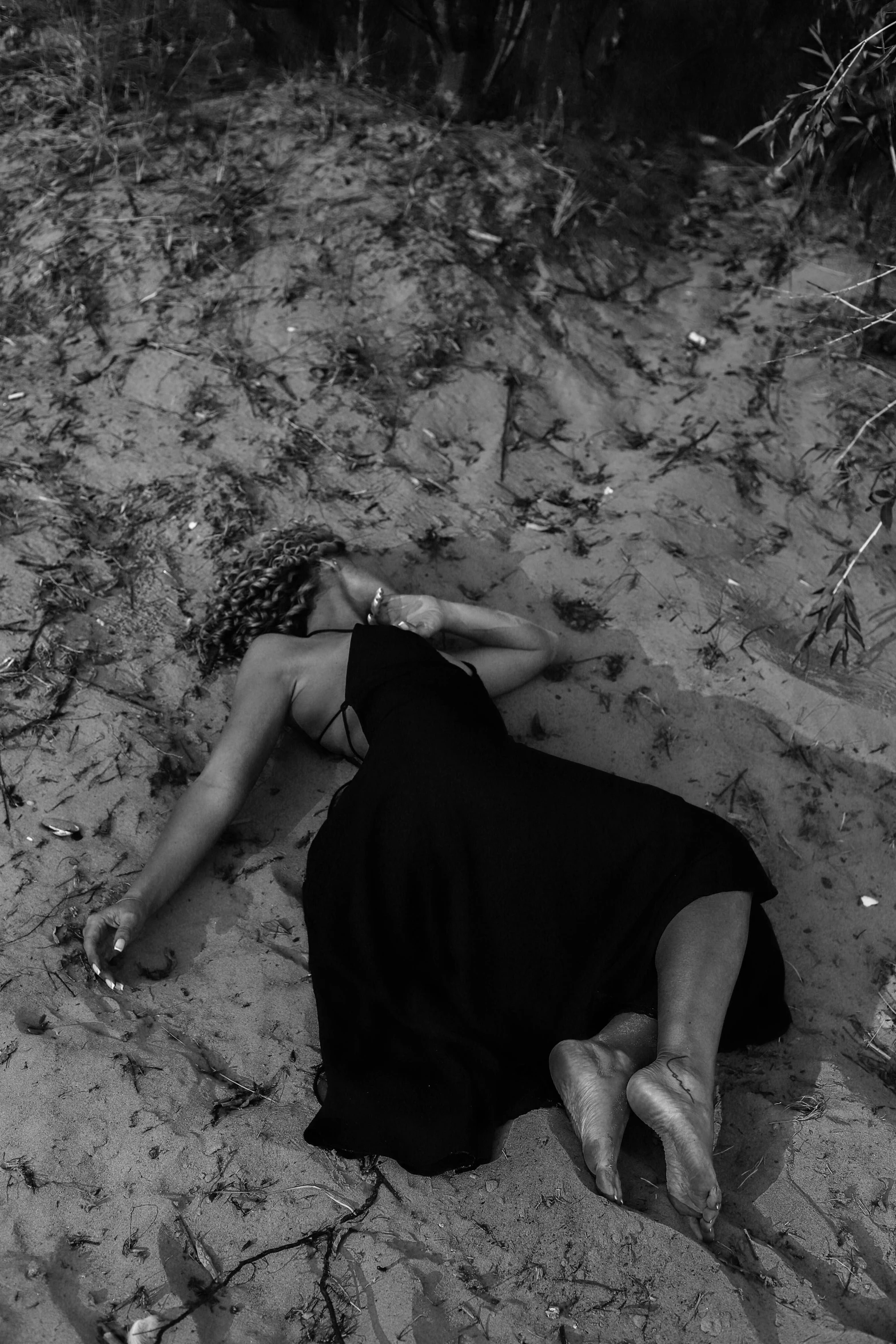 a black and white photo of a woman laying in the sand, tumblr, conceptual art, homicide, southern gothic, photograph taken in 2 0 2 0, heartbroken
