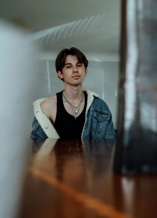 a man sitting at a table in front of a mirror, an album cover, inspired by Jean Malouel, trending on pexels, hyperrealism, portrait androgynous girl, headshot profile picture, standing in a dimly lit room, high quality upload