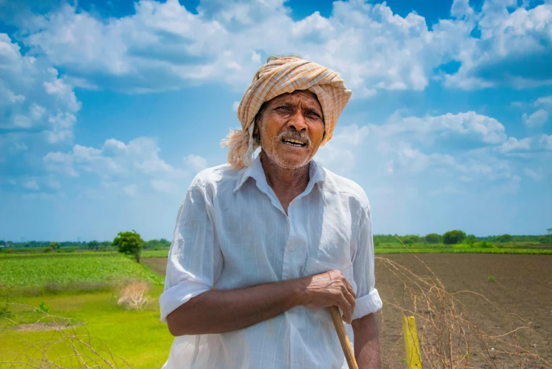 a man standing in a field with a stick, by Scott M. Fischer, pexels contest winner, samikshavad, portrait image, farming, background image, india