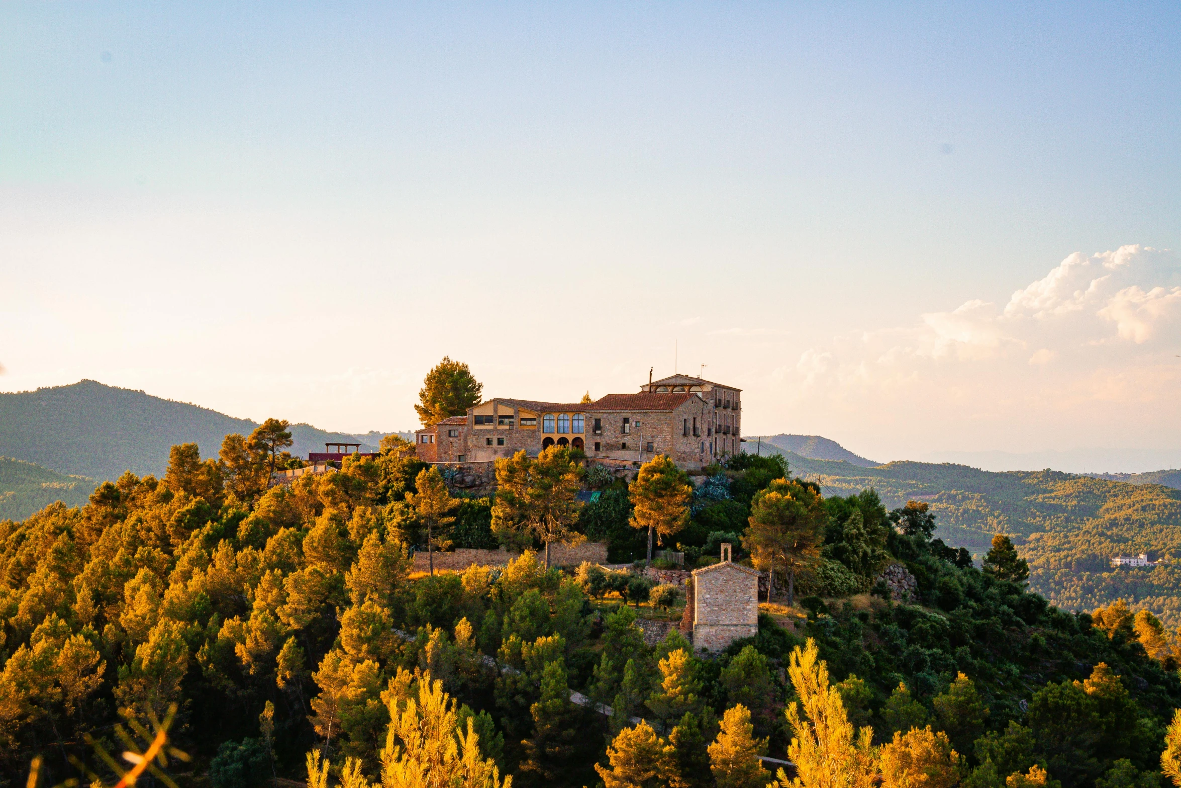 a large building sitting on top of a lush green hillside, inspired by Serafino De Tivoli, pexels contest winner, pink golden hour, costa blanca, conde nast traveler photo, preserved historical