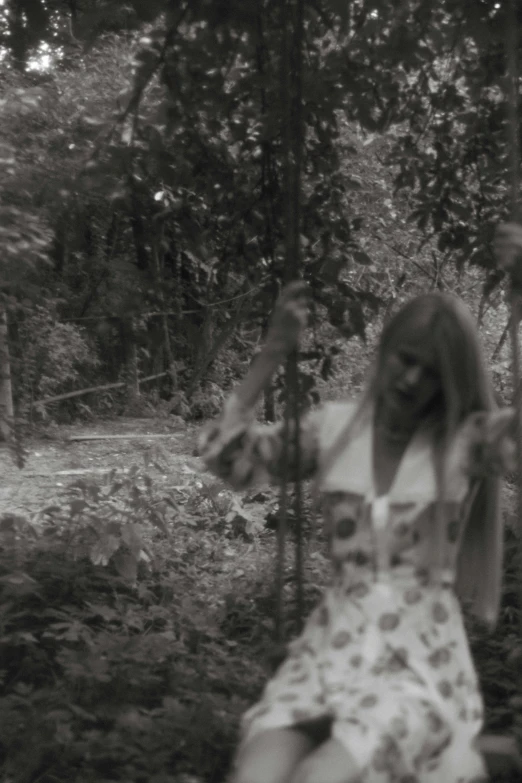 a black and white photo of a woman on a swing, inspired by Kati Horna, screenshot of found footage, overgrown, low quality footage, promo image