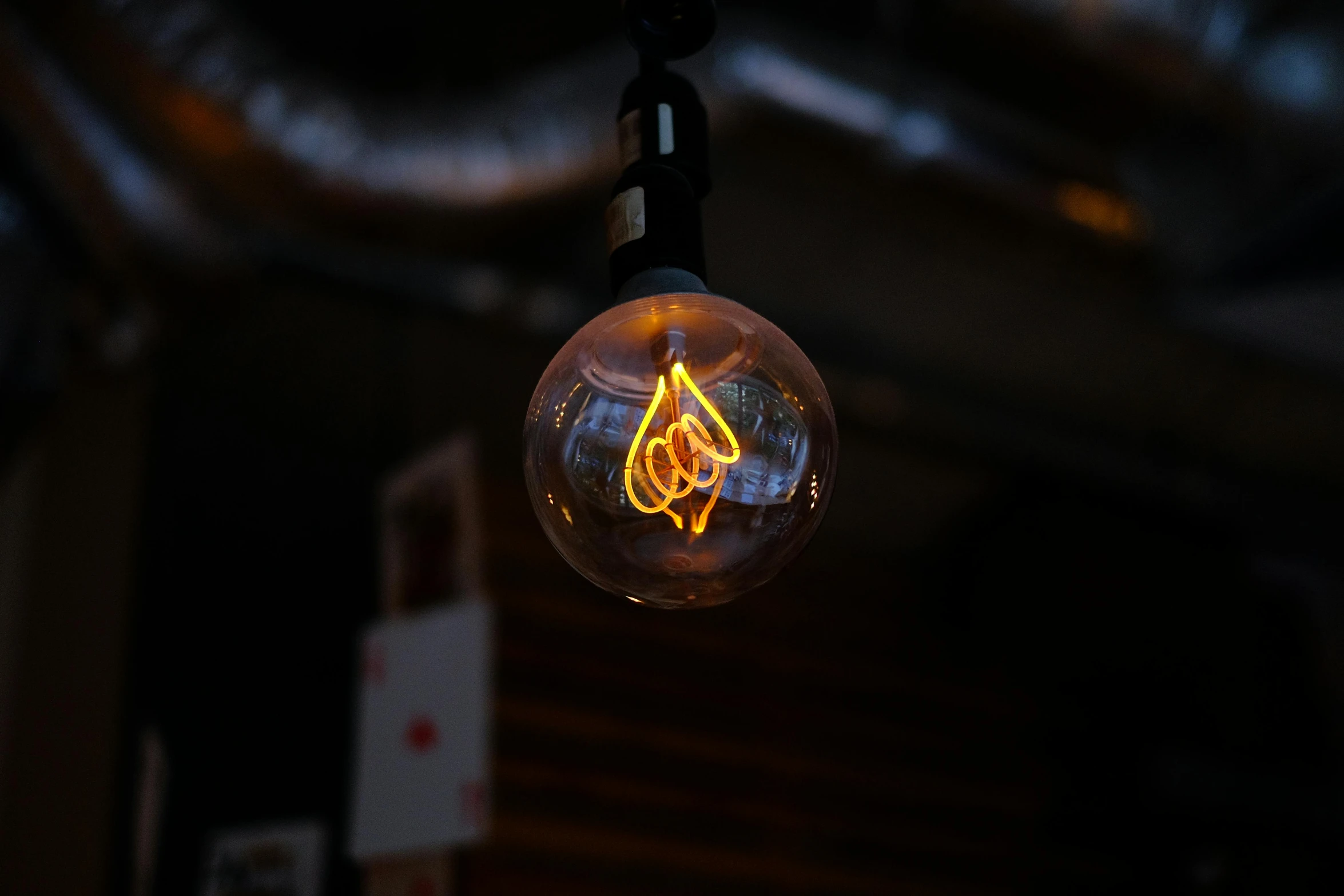 a close up of a light bulb hanging from a ceiling, inspired by Elsa Bleda, unsplash, graffiti, brown, neon ligh, cafe lighting, nixie tube