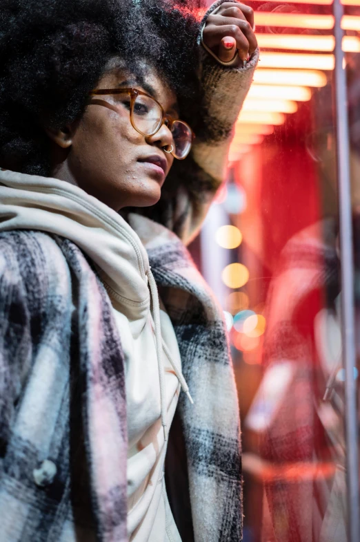 a woman standing in front of a store window, trending on unsplash, nerdy black girl super hero, winter season, square rimmed glasses, close to night