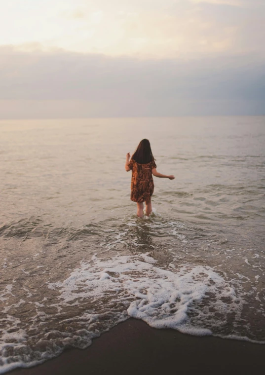 a woman standing in the water at the beach, a picture, inspired by Elsa Bleda, unsplash contest winner, renaissance, walking away from camera, teenage girl, rippling, lynn skordal