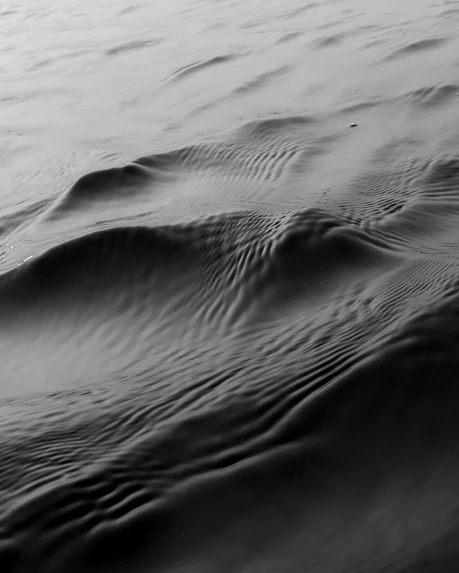 a black and white photo of a body of water, inspired by Edward Weston, unsplash, conceptual art, dmt ripples, on the surface of mars, sand swirling, ultrafine detail ”