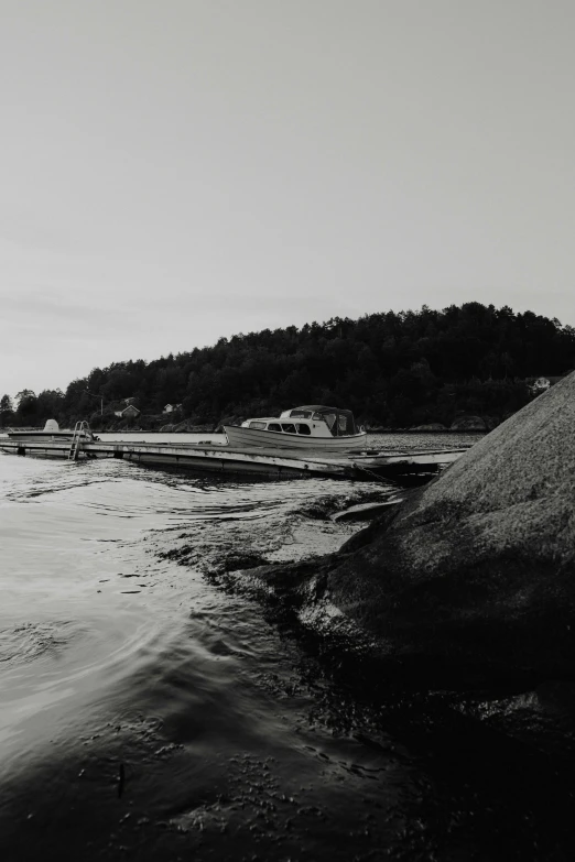 a black and white photo of a body of water, a black and white photo, by Jesper Myrfors, unsplash, purism, fishing village, rock and sand around, late summer evening, shipyard