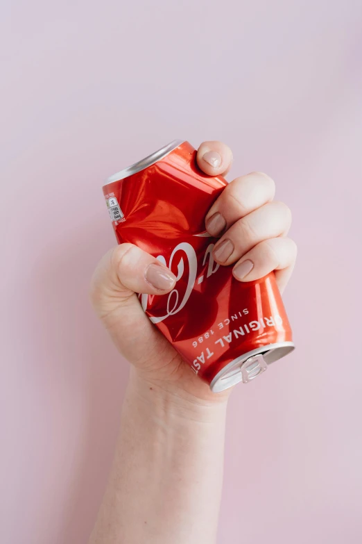 a person holding a can of coke in their hand, inspired by Dorothy Coke, pexels contest winner, coral red, 👅 👅, shiny crisp finish, broken down