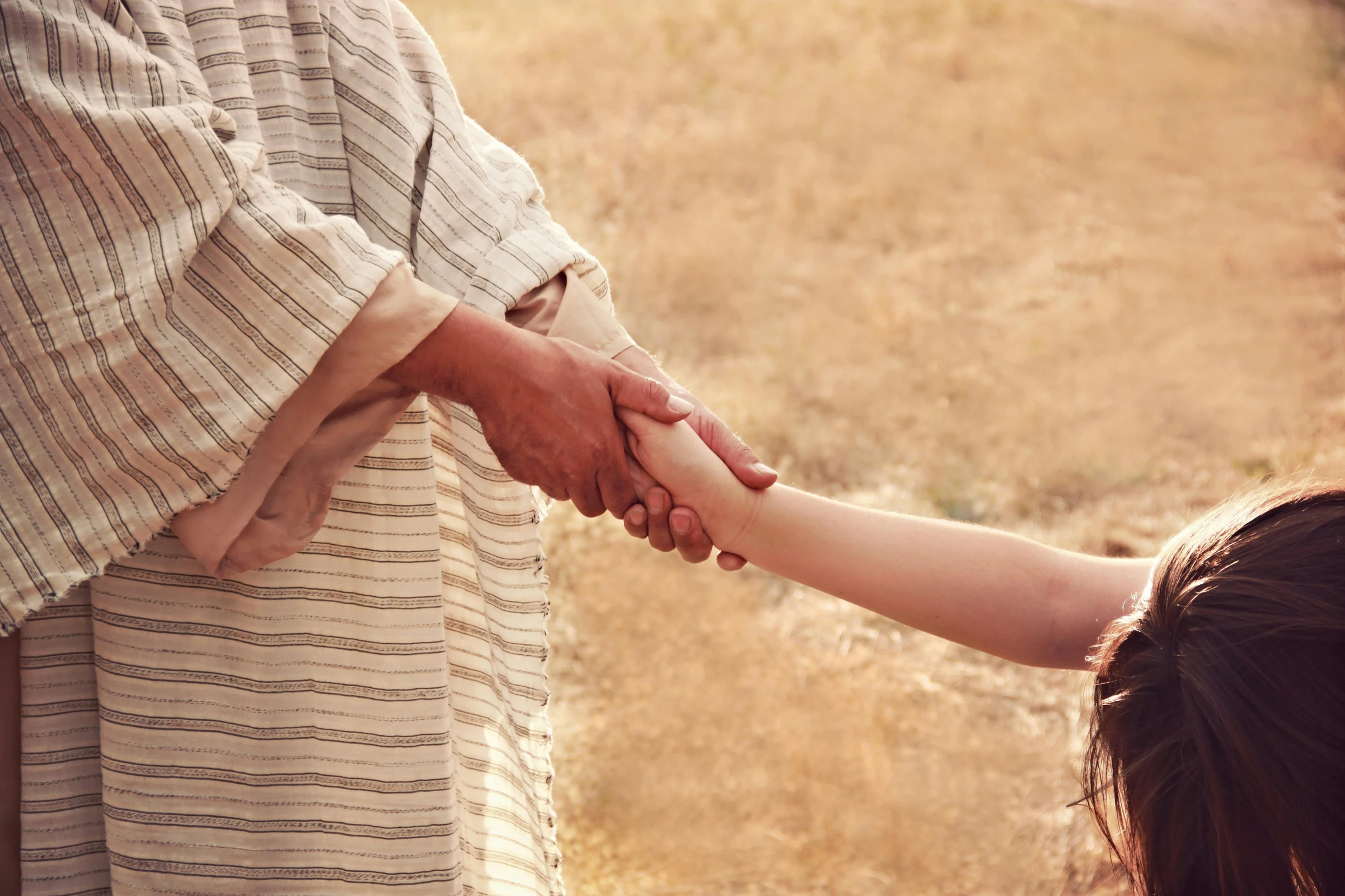 a person holding a child's hand in a field, unsplash, incoherents, dressed like jesus christ, actress, 15081959 21121991 01012000 4k, boy girl traditional romance