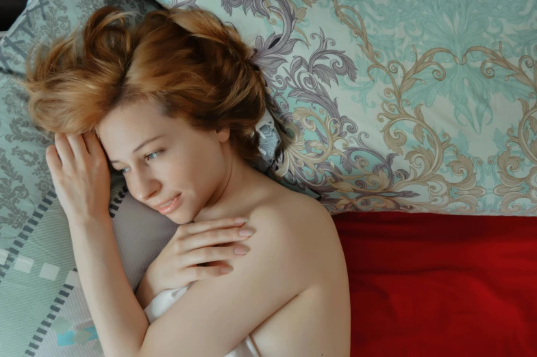 a woman laying on a bed with a laptop, a photo, trending on pexels, romanticism, a redheaded young woman, wistful bosom, gif, sorrow