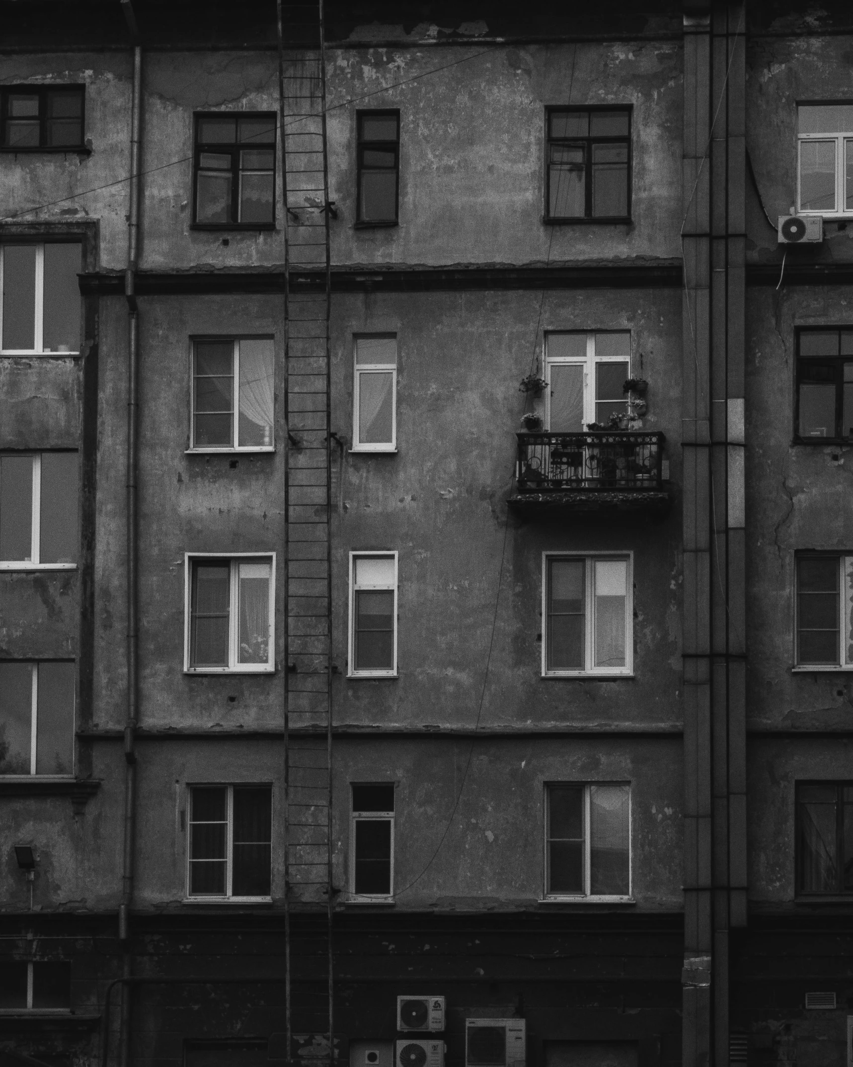 a black and white photo of a tall building, by Tamas Galambos, pexels contest winner, soviet apartment, balcony scene, square, 85mm nd 5