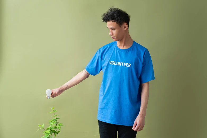 a man standing next to a potted plant, inspired by Yves Klein, unsplash, graffiti, blue tight tshirt, official product photo, wearing plumber uniform, light-blue