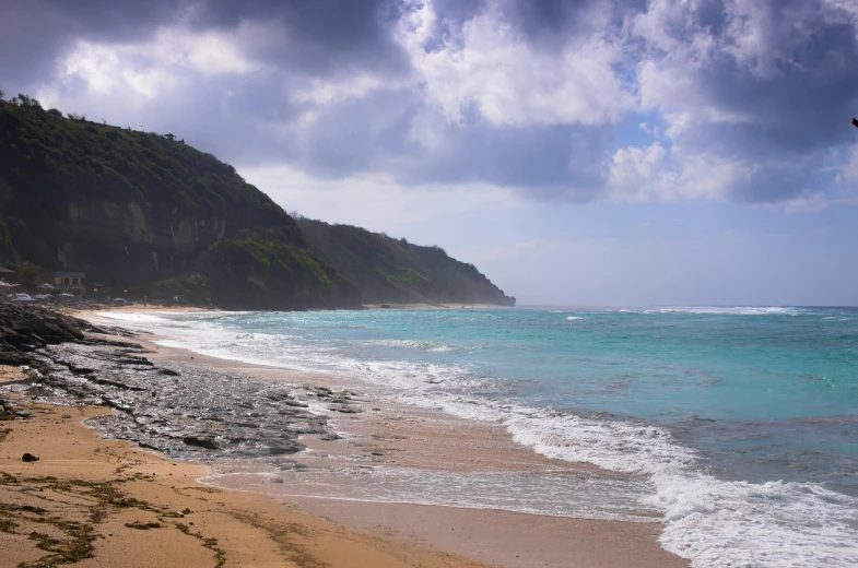 a man flying a kite on top of a sandy beach, by Adam Manyoki, pexels contest winner, renaissance, kauai springtime, puddles of turquoise water, grey, on the beach at noonday