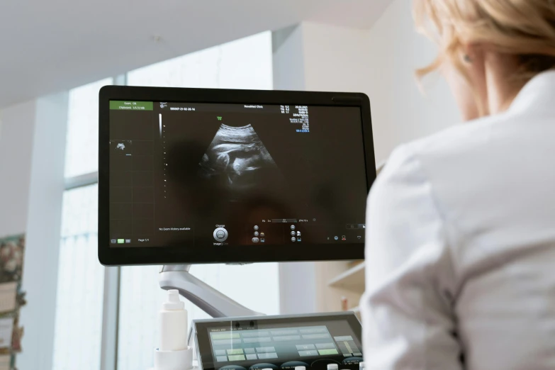a woman in a white shirt is looking at a computer screen, membrane pregnancy sac, in the center of the image, thumbnail, ultra nd
