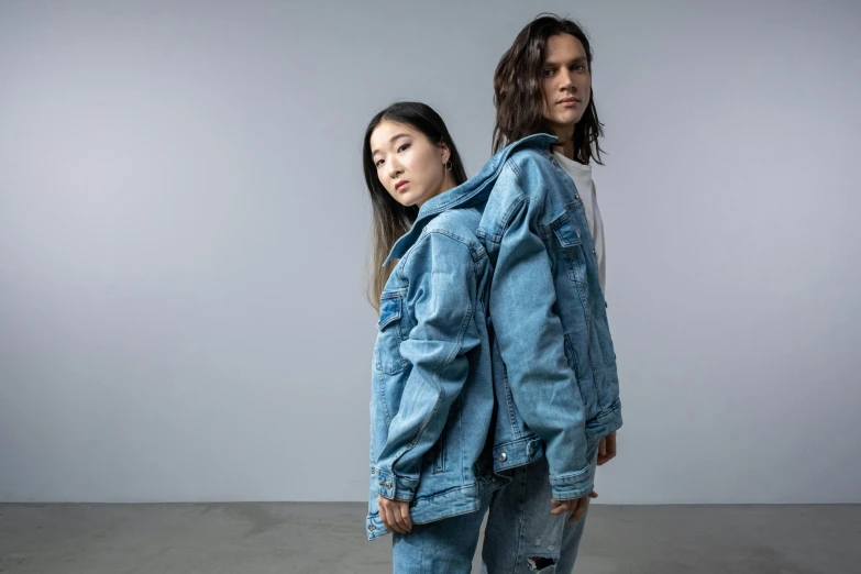 a couple of people standing next to each other, an album cover, inspired by Wang Duo, trending on pexels, hyperrealism, denim jacket, half asian, battle pose, julian ope