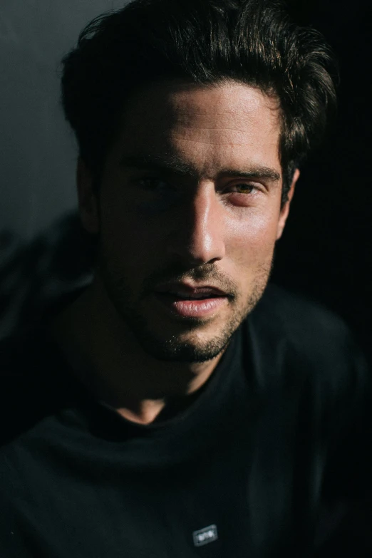 a close up of a person wearing a black shirt, by Jacob Toorenvliet, daniel ricciardo, lean man with light tan skin, rugged face, entertaining