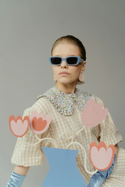 a woman holding a vase with hearts cut out of it, an album cover, inspired by Henriette Grindat, trending on tumblr, blue sunglasses, pastel clothing, kirsi salonen, 8 0. lv