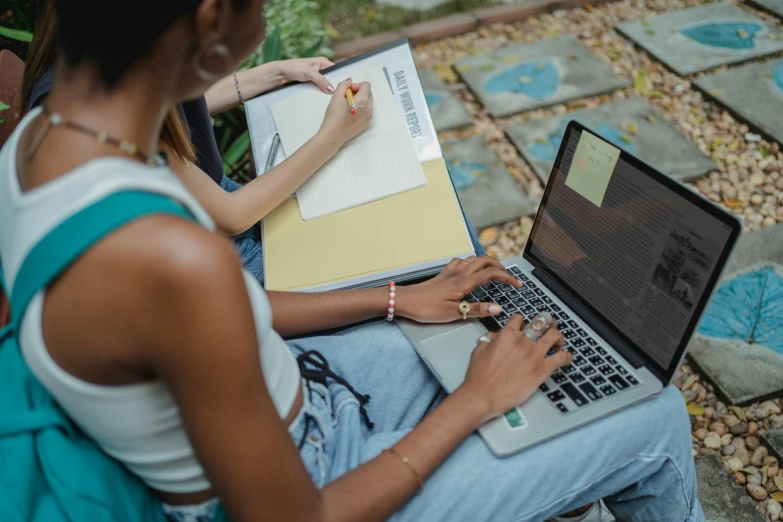 a woman sitting on a bench using a laptop computer, trending on pexels, academic art, woman holding another woman, with notes, top down shot, sitting in the garden