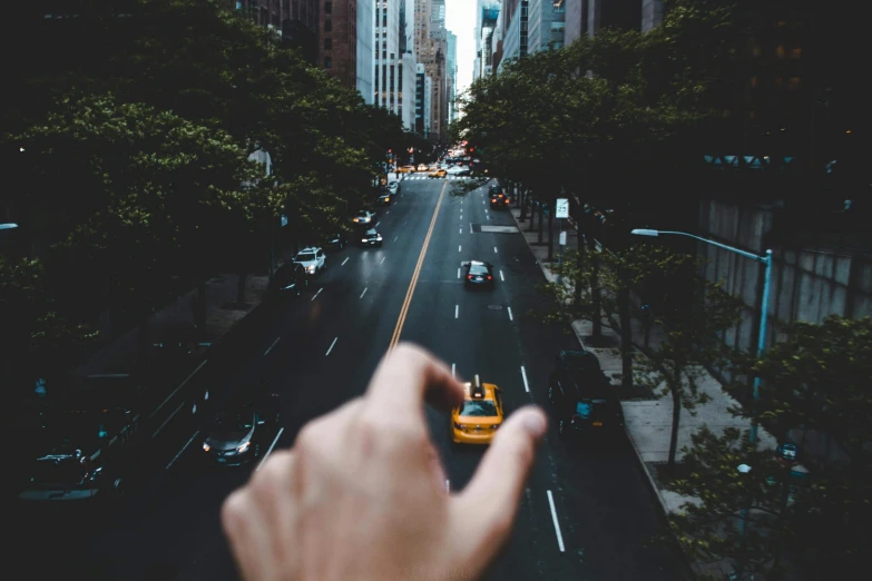 a person taking a picture of a city street, inspired by Thomas Struth, pexels contest winner, raised hand, driving, birdseye view, new york backdrop