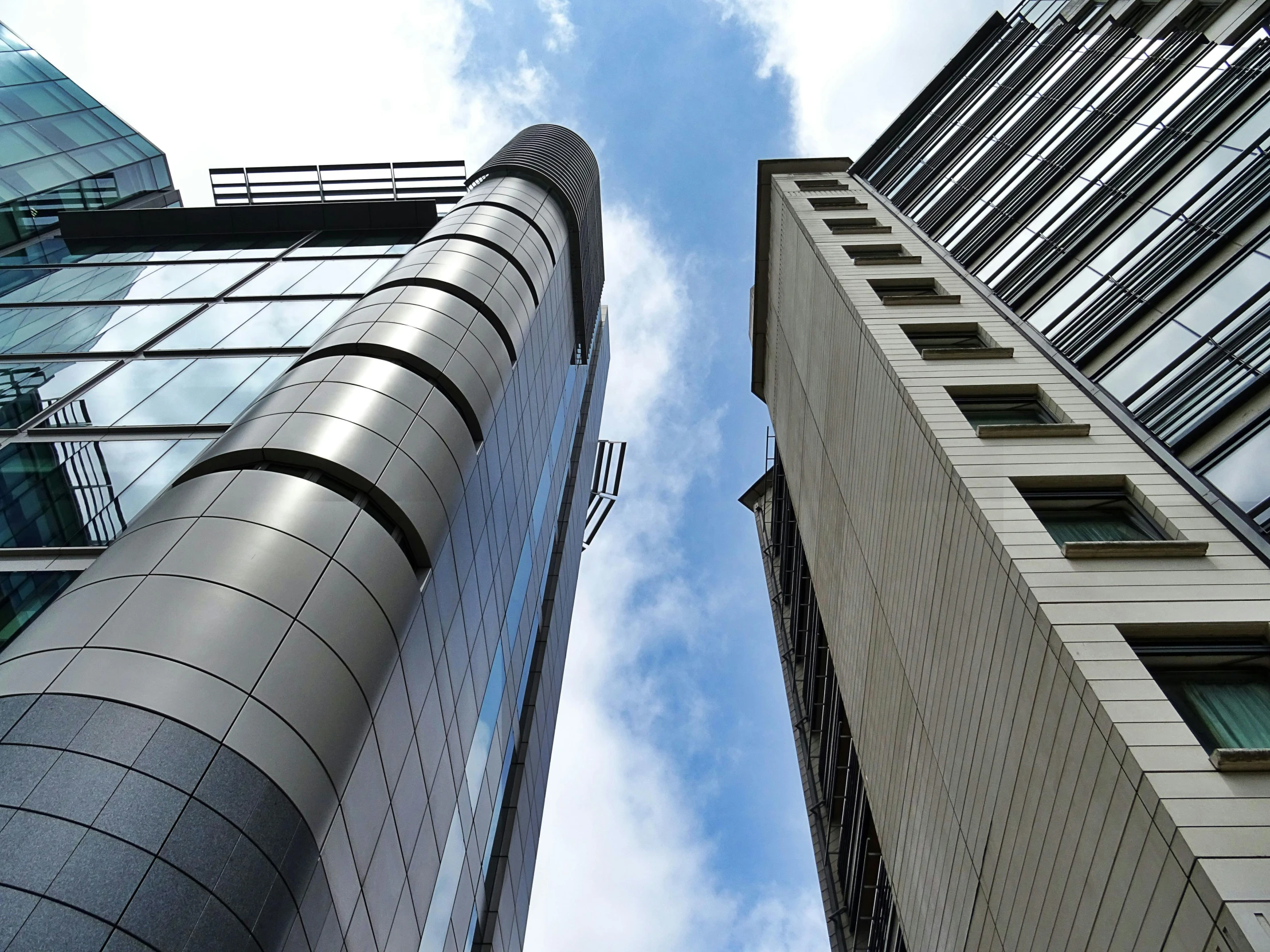 a couple of tall buildings next to each other, a photo, by David Donaldson, iron cladding, high quality upload, multiple stories, up shot