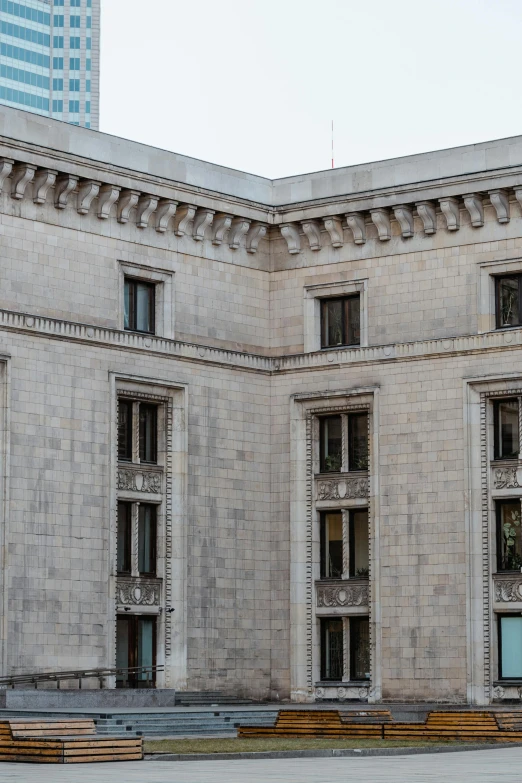 a man riding a skateboard up the side of a building, by Rachel Whiteread, neoclassicism, many large windows, neoclassical police station, highly detailed stonework, view from the street