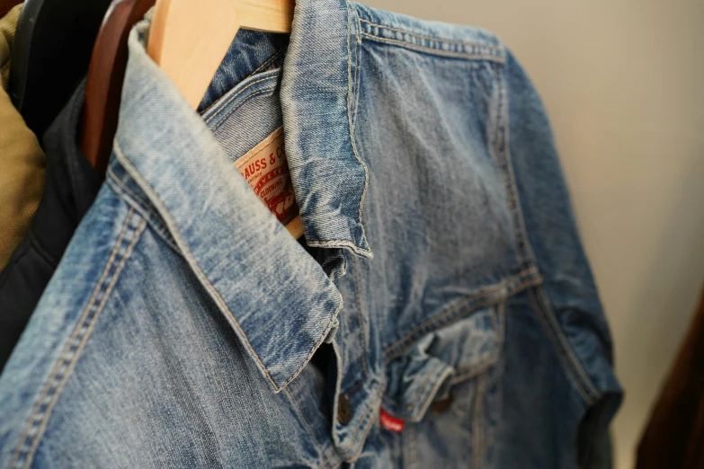 a pair of jeans hanging on a clothes rack, unsplash, process art, jean jacket, close up shot from the side, aged 13, style jean giraud
