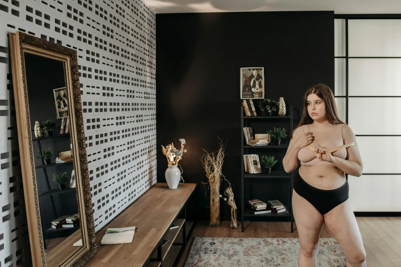 a woman standing in front of a mirror in a room, black underwear, plus-sized, realistic », low quality photo