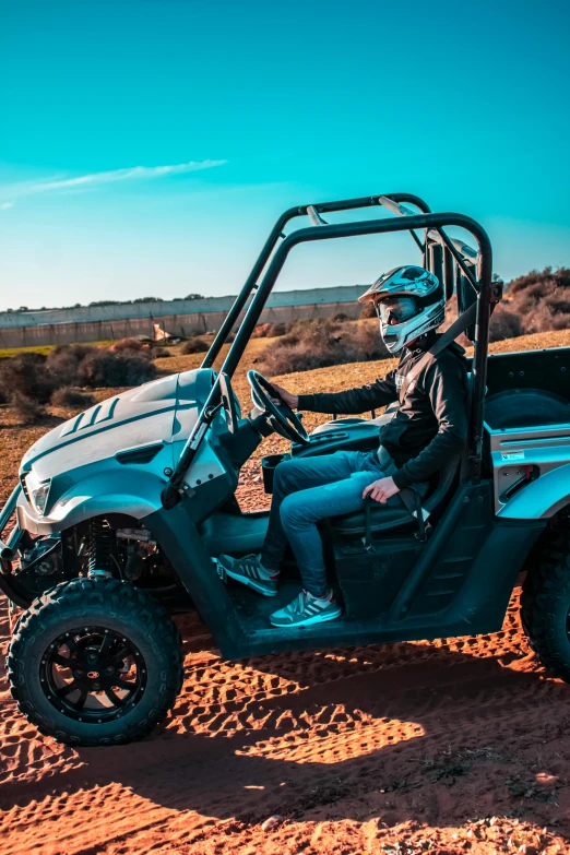 a man driving a blue utt in the desert, dressed in black body armour, buggy, outdoors setting, profile image