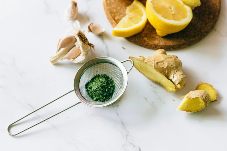 a cutting board with lemons, garlic, and a strainer, trending on pexels, green tea, infused with aurora borealis, moringa juice, 🎨🖌️