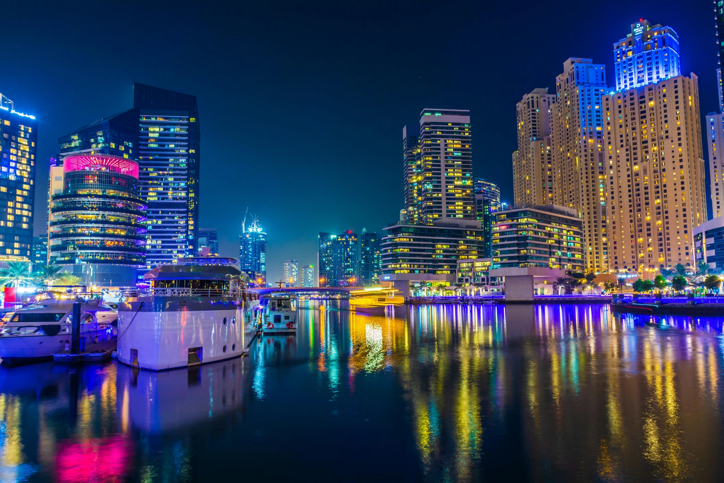 a large body of water surrounded by tall buildings, by Bernardino Mei, pexels contest winner, hurufiyya, vibrant lights, middle east, city docks, slide show