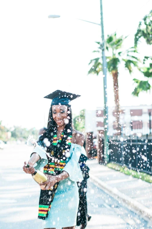 a woman wearing a graduation gown and holding a bouquet of flowers, by Stokely Webster, pexels contest winner, bubbles in the air, photo of a black woman, oh the places you'll go, splashes