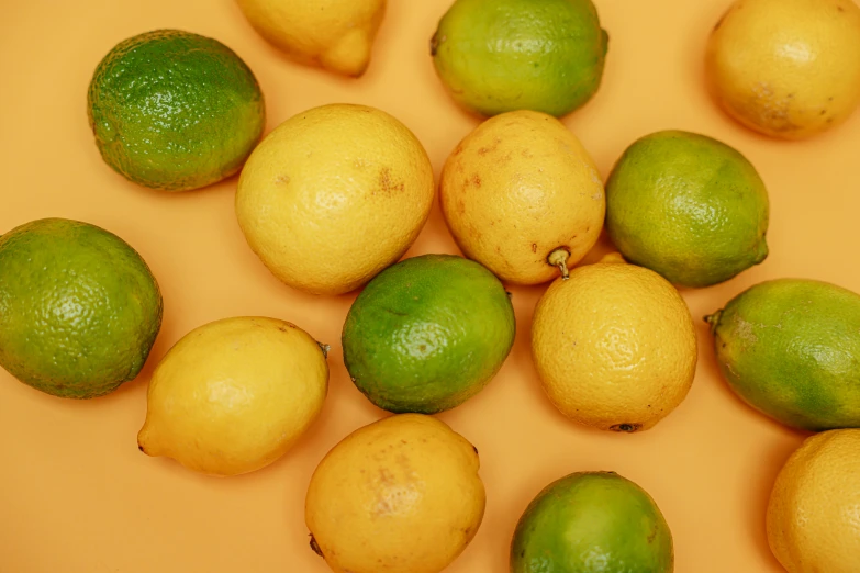a bunch of lemons and limes on a table, by Carey Morris, trending on pexels, yellow background, background image, 2000s photo
